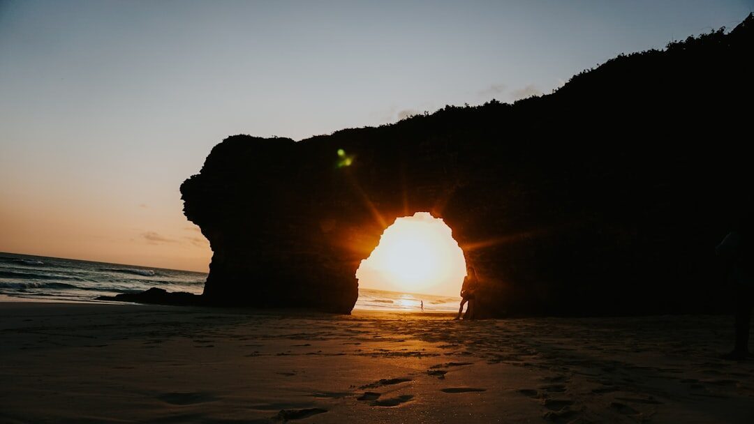 The sun setting through a sea-stack arch on the east coast.