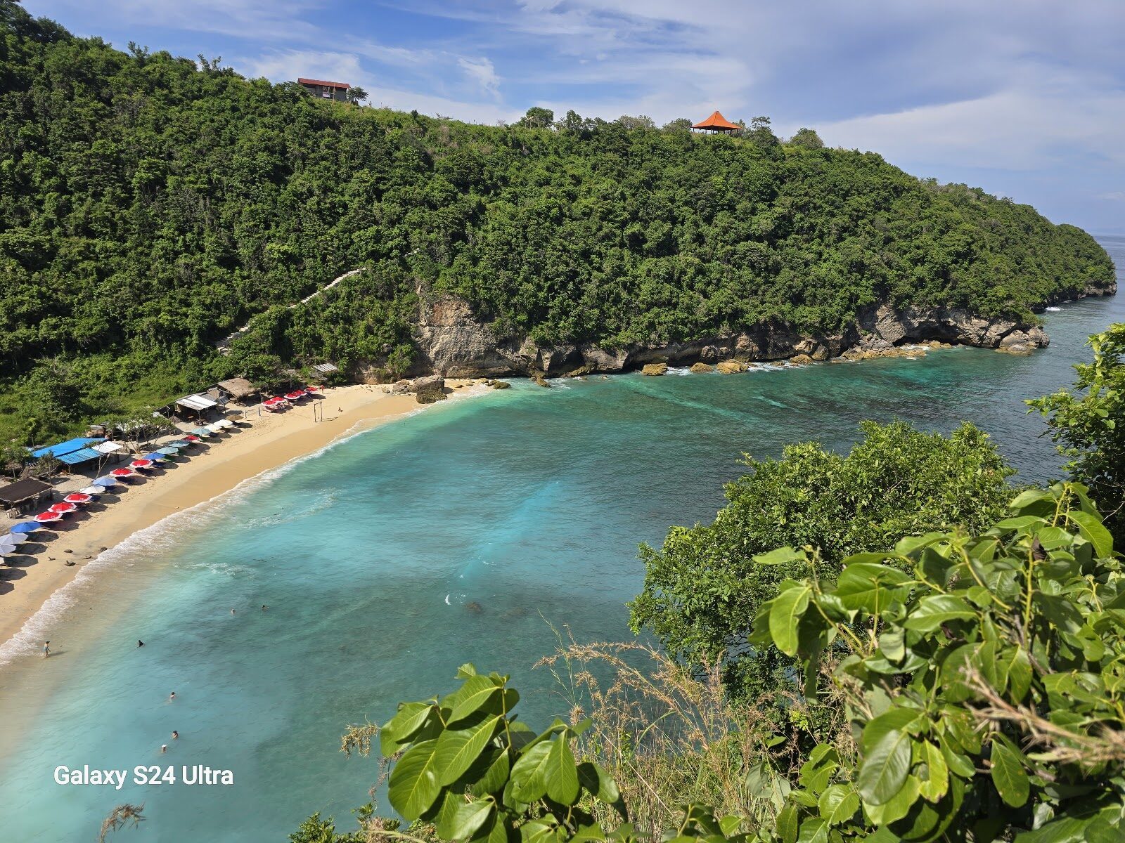 Neighbouring Atuh Beach, its sunshades bright on the sand below the cliffs.