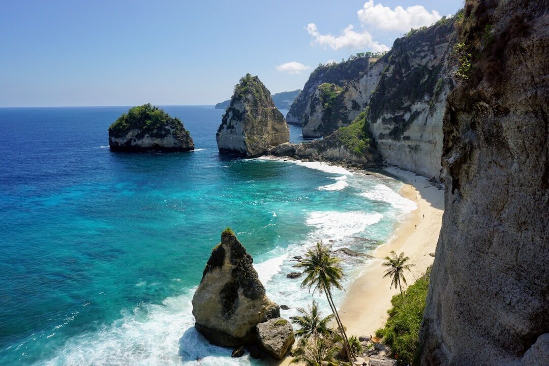 Diamond Beach — white sand, leaning palms and sea stacks on Nusa Penida's east coast.