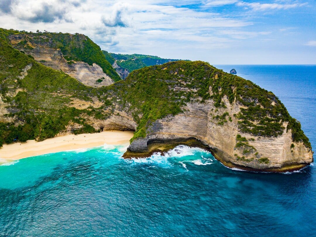An aerial angle on the Kelingking headland and its curving beach.