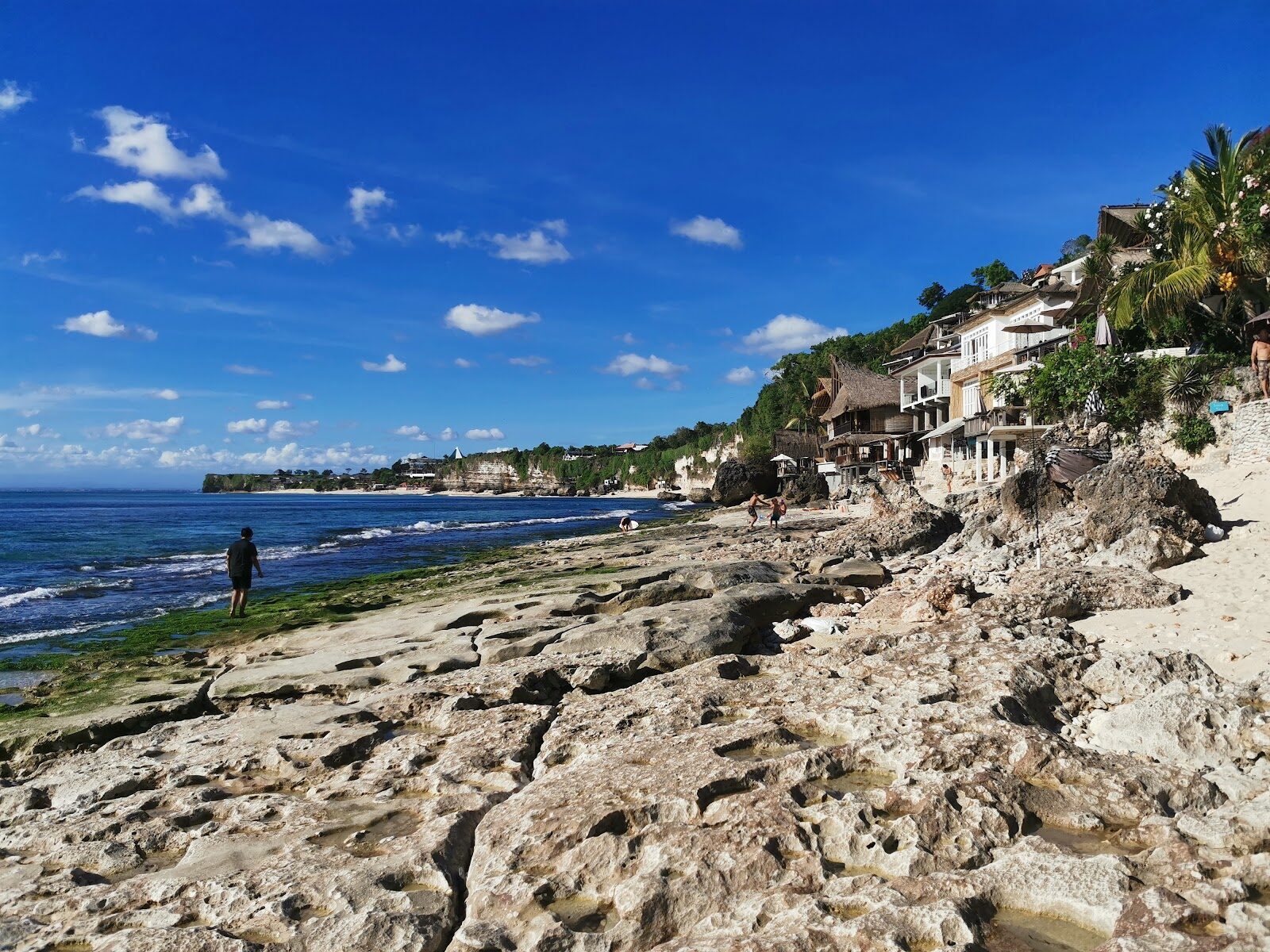 The cliff village seen from the rocky reef at low tide.