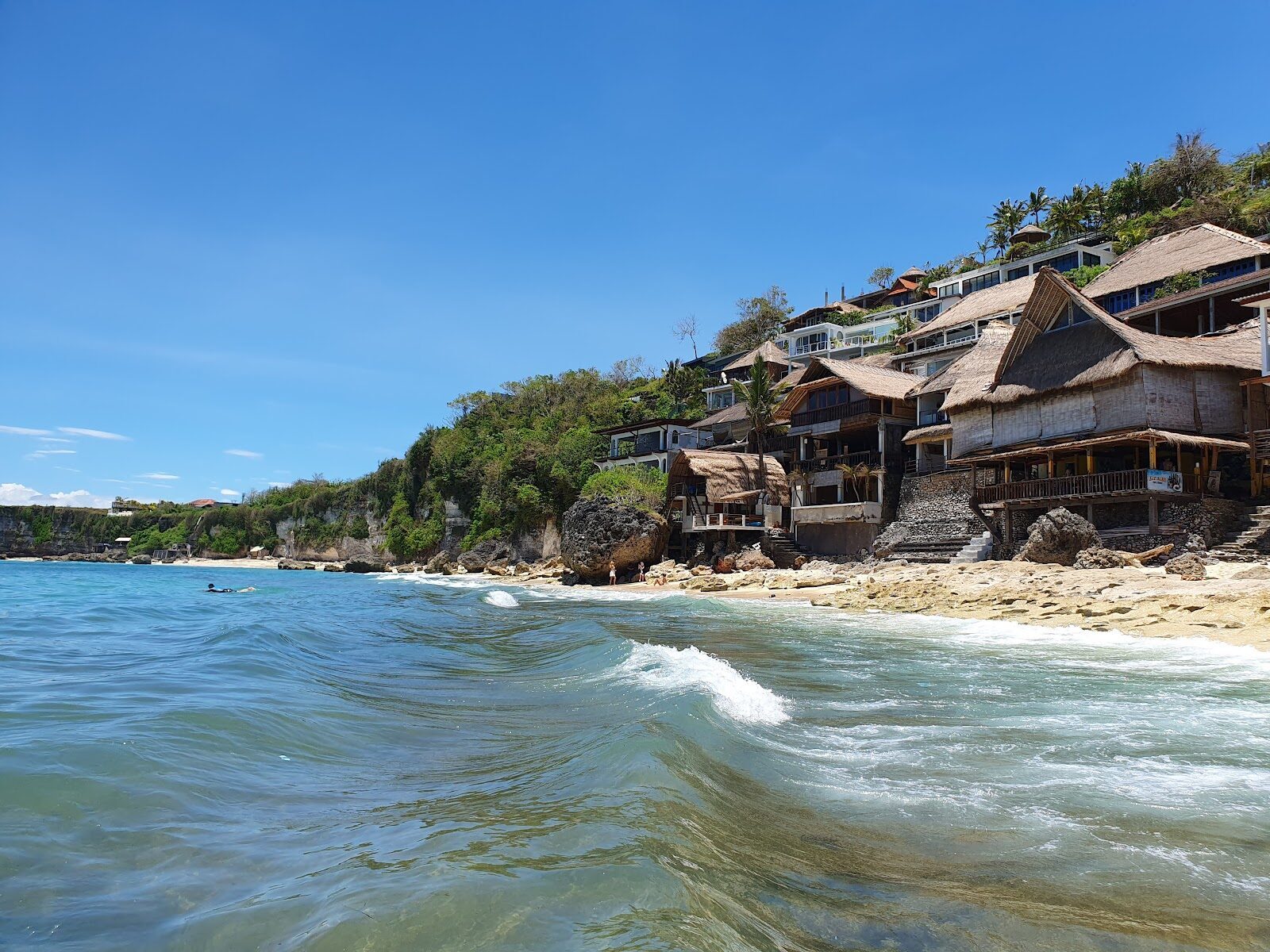 Cafes and rooms stacked up the cliff face above Bingin's sand.