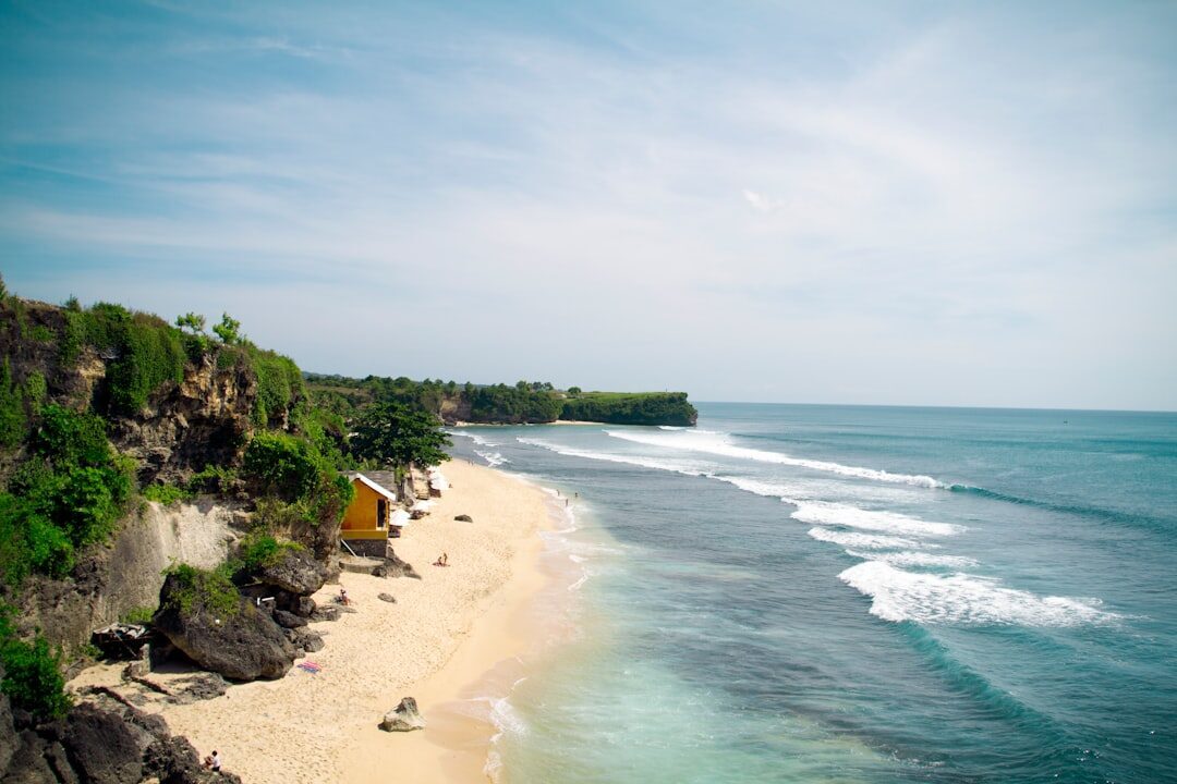 The beach and its scattered warungs seen from the clifftop.