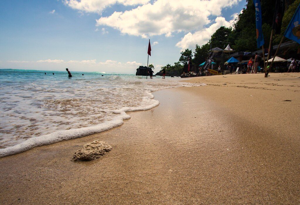 Wave-wash over the sand at the water's edge, the reef just offshore.
