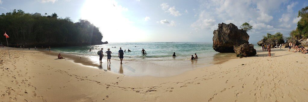 The little beach and its rock headland, busy with visitors.