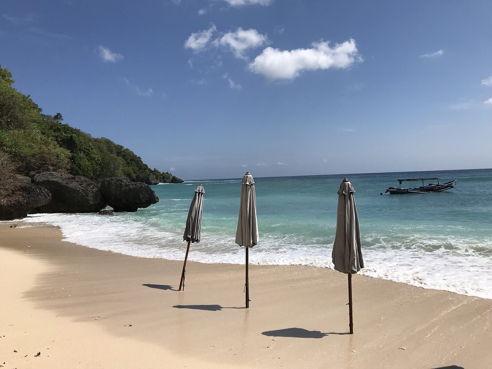 The Padang Padang cove — a pocket of sand hemmed by rock, umbrellas set out before the crowds arrive.