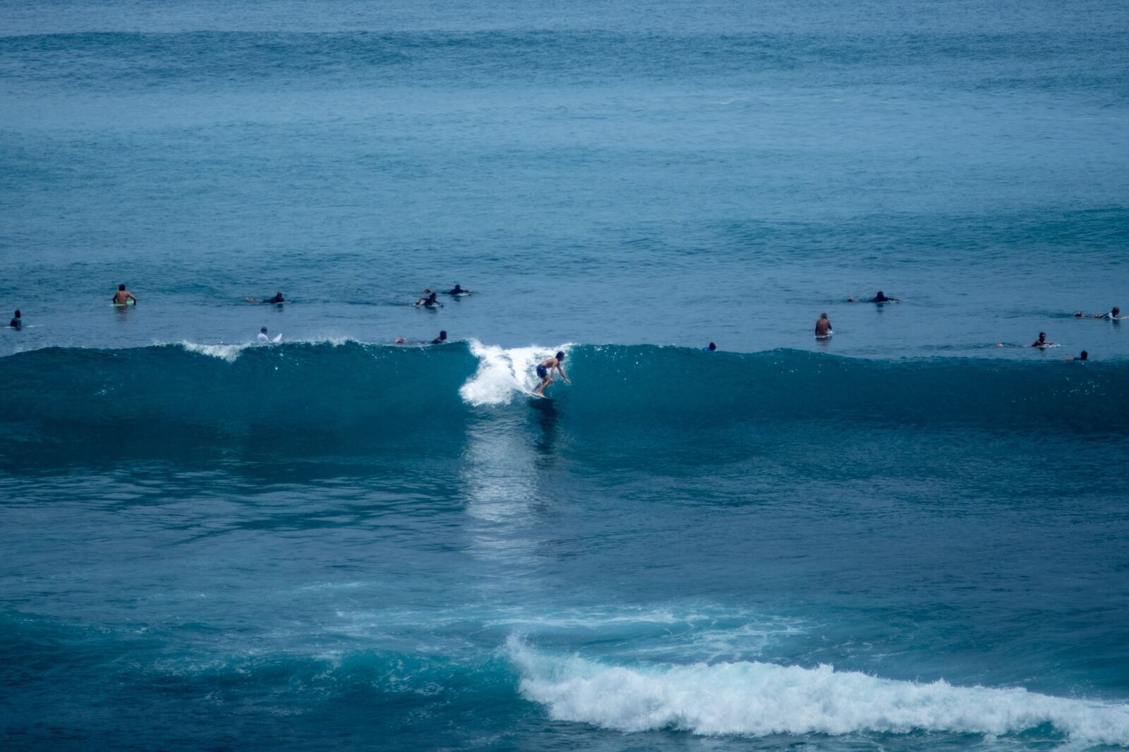 Surfers waiting in the lineup as a set rolls through.