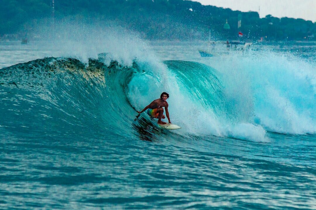 A surfer deep inside a hollow reef barrel — the kind of heavy left the Bukit is known for.
