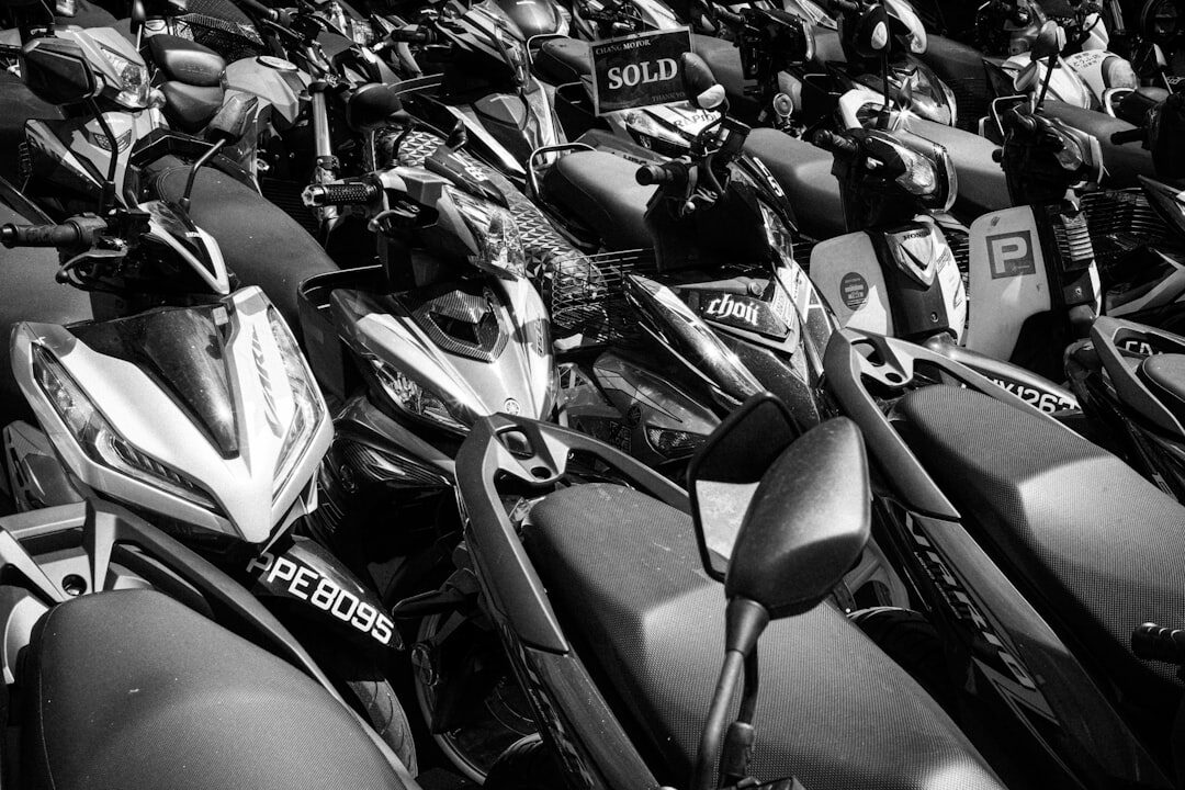 Automatic scooters packed tight in a dealer's lot, one tagged 'SOLD'.