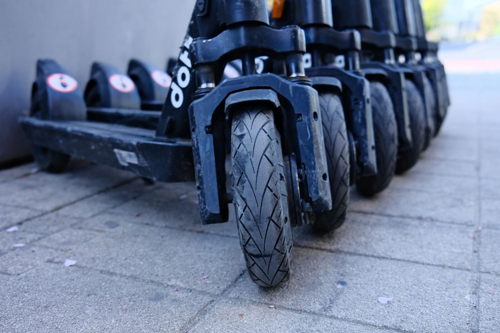 A close row of parked scooters, front wheels and tyres lined up — the contact patch to check before you ride off.