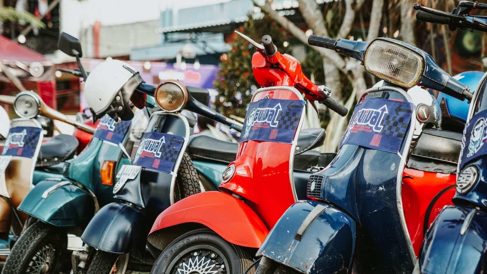 A rank of coloured scooters lined up for hire.