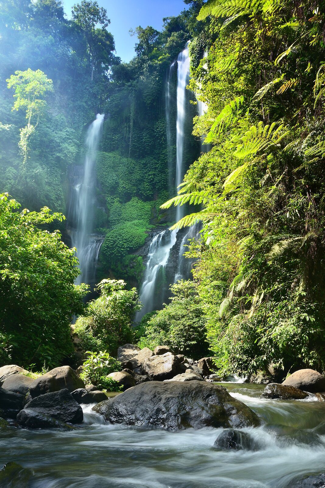 The cascades seen across the misty river at the bottom of the gorge.