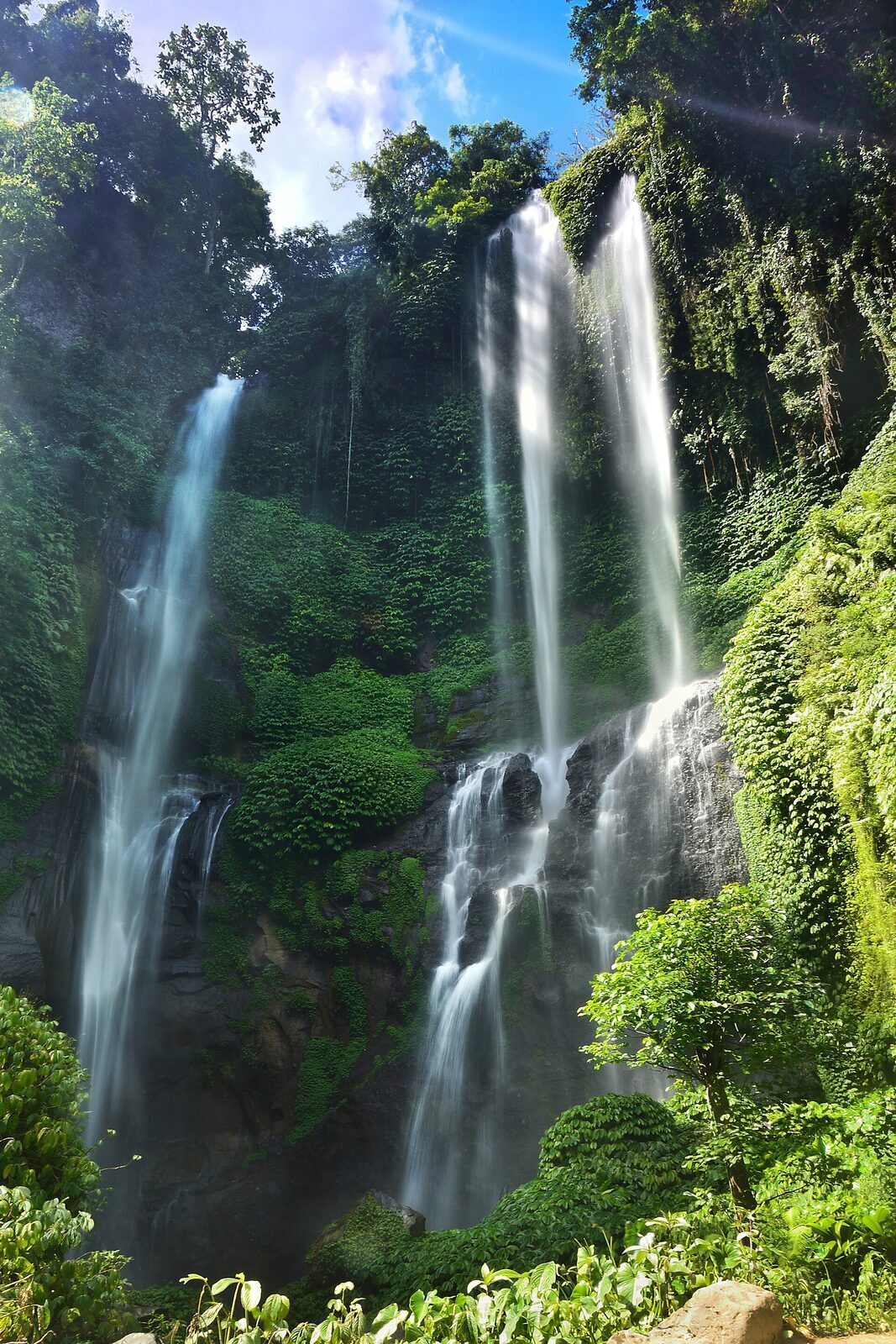 The fan of tall cascades that gives Sekumpul its name — 'sekumpul' means 'a group.'