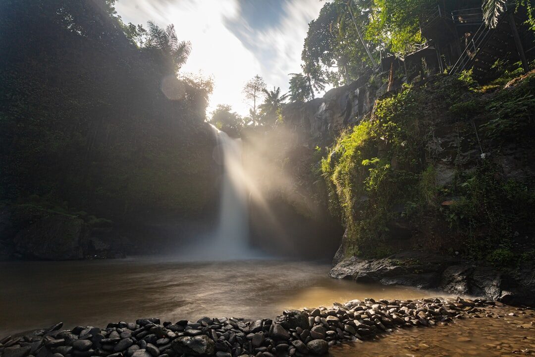The rocky riverbed below the falls, threaded with light and spray.