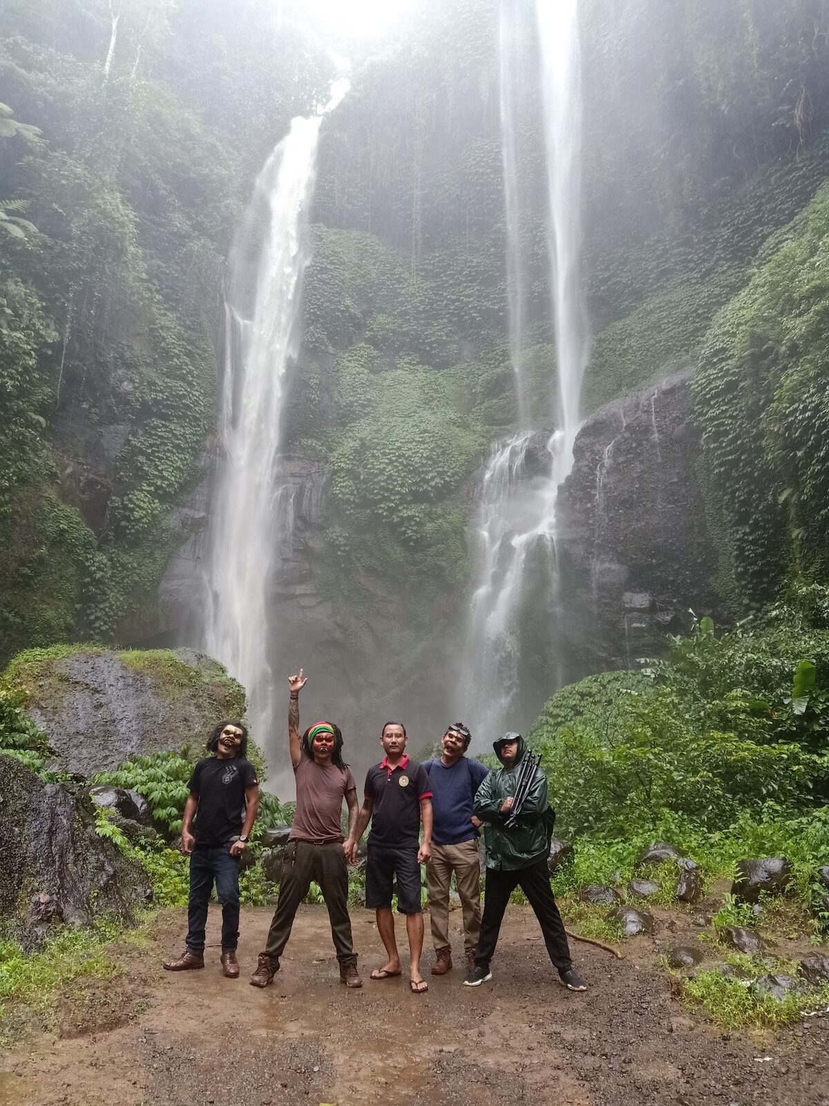 Visitors dwarfed at the foot of the falls — the sense of scale you climb down for.