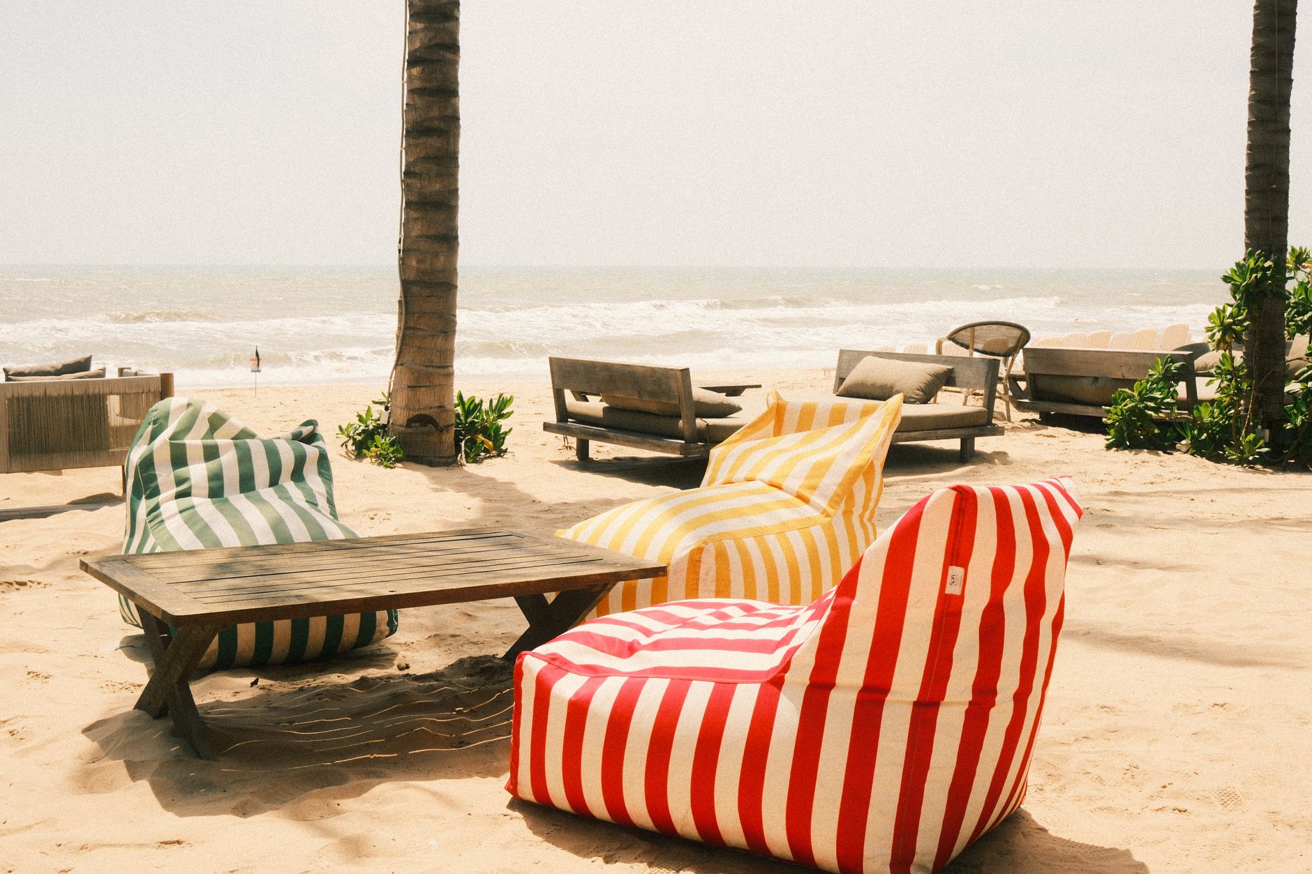 Striped beanbags under a palm at a Seminyak beach club