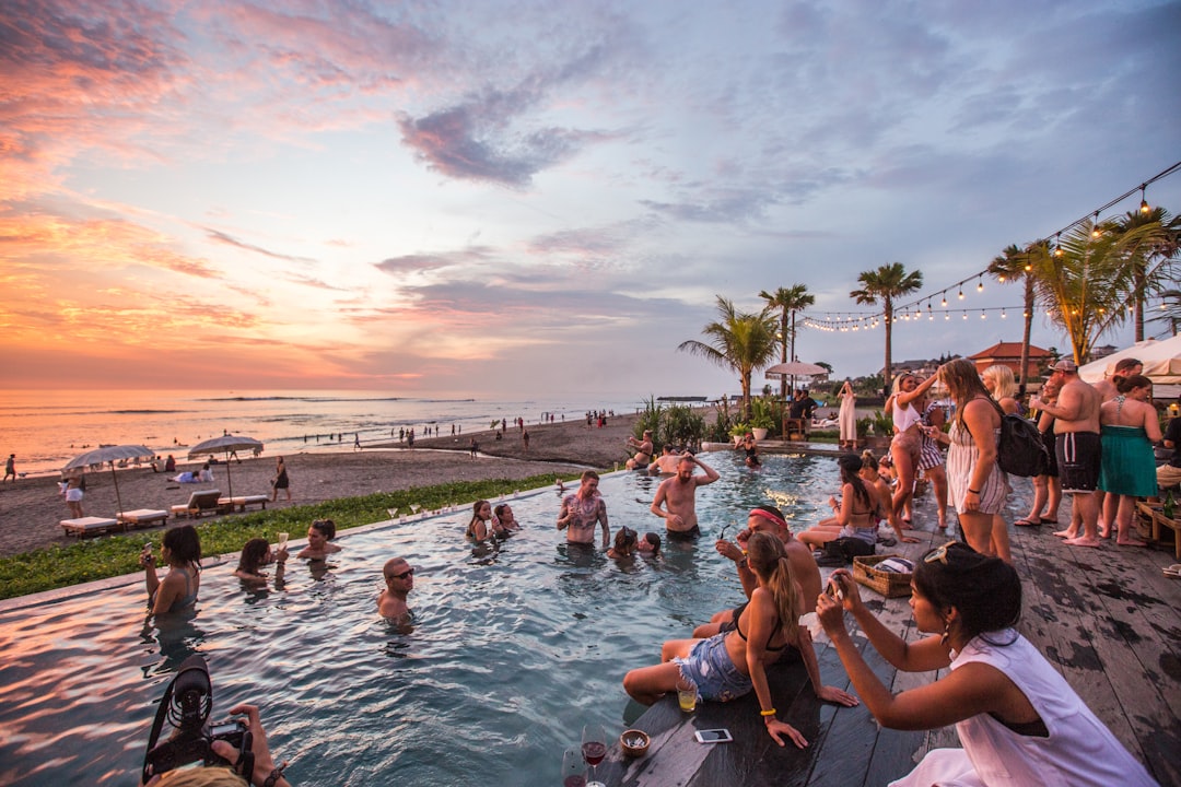 A beach-club pool party at sunset under string lights, Seminyak