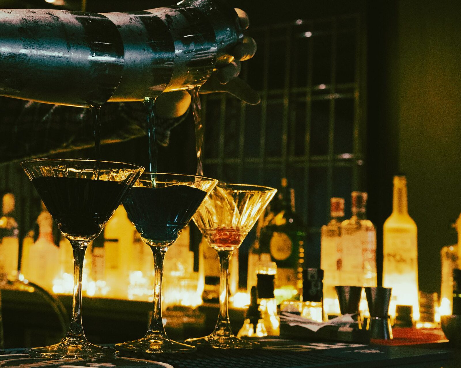 A row of cocktails — cheap 'free-pour' spirits are exactly where the methanol risk hides.
