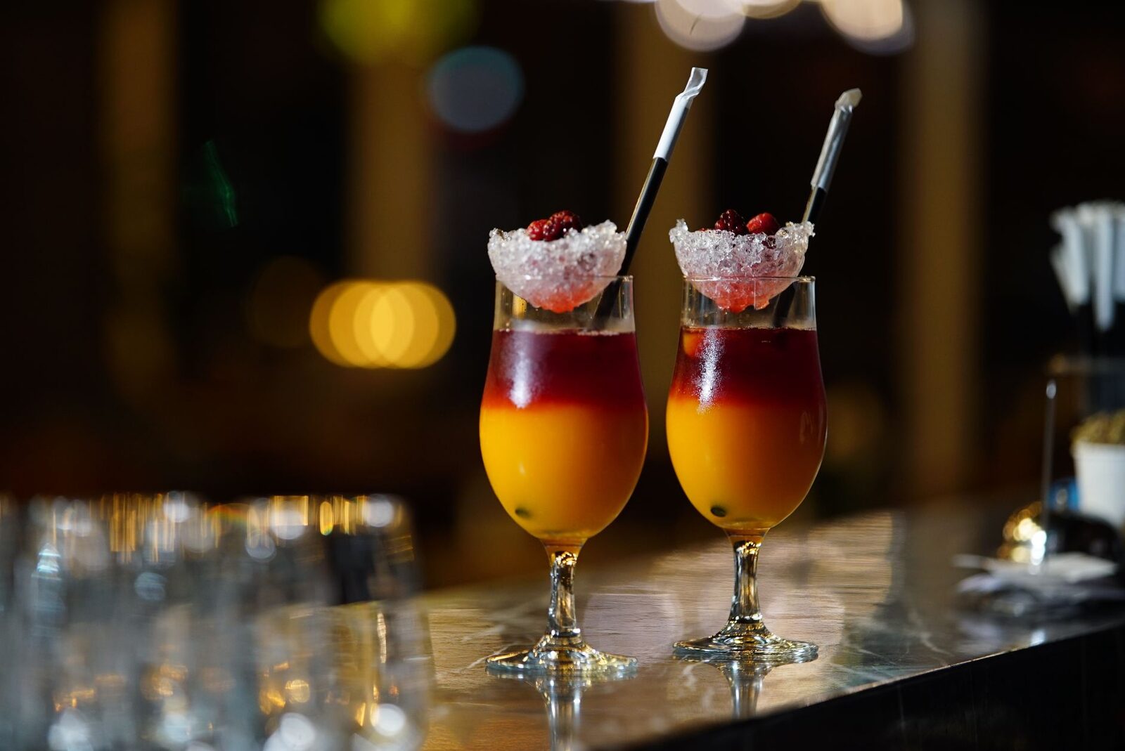 Two cocktails on the bar — and the single most useful rule of a Bali night out: watch your drink, and stick to sealed or brand-name pours.