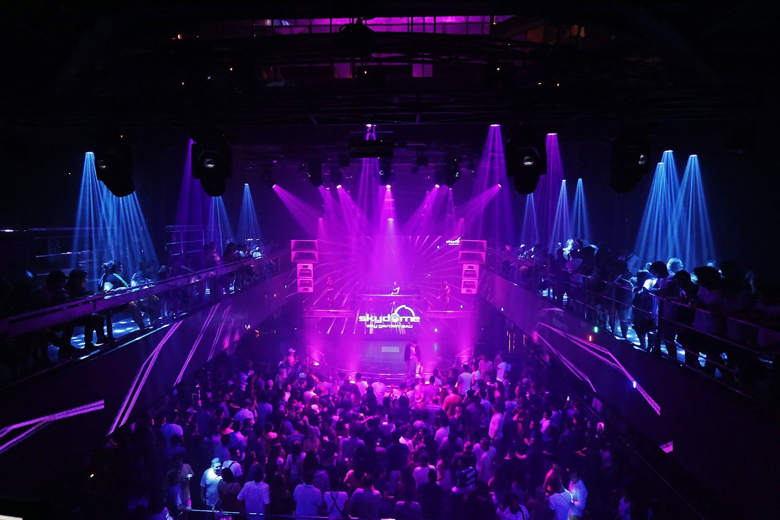 A packed club night — lasers, volume, a crowd. The mainstream nightlife most people come for, with the fringe operating at its edges.