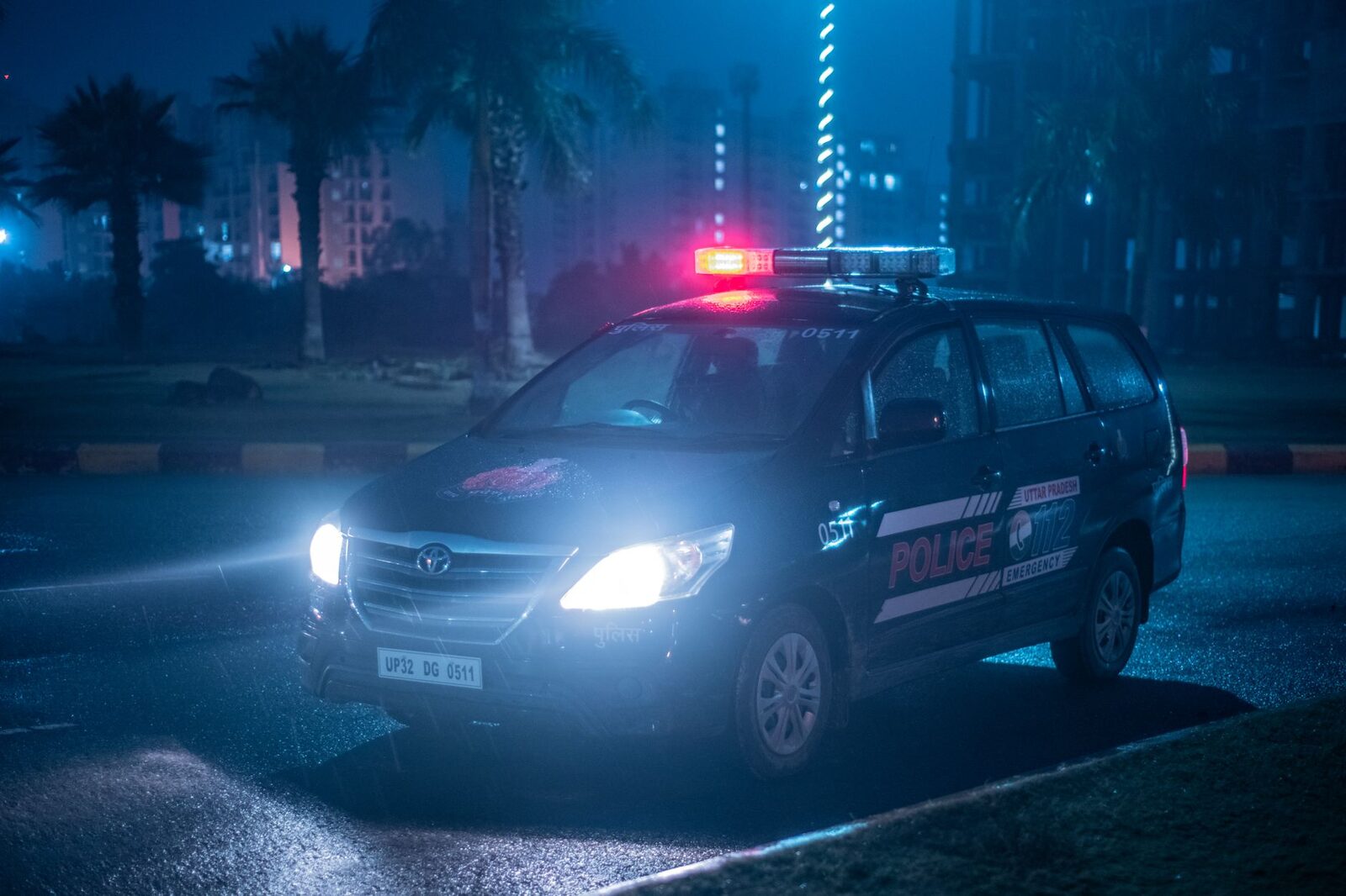 A police vehicle out on a wet night street.