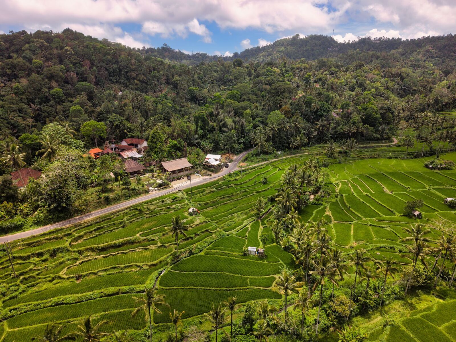 Village houses tucked into the green valley, hills rising behind.