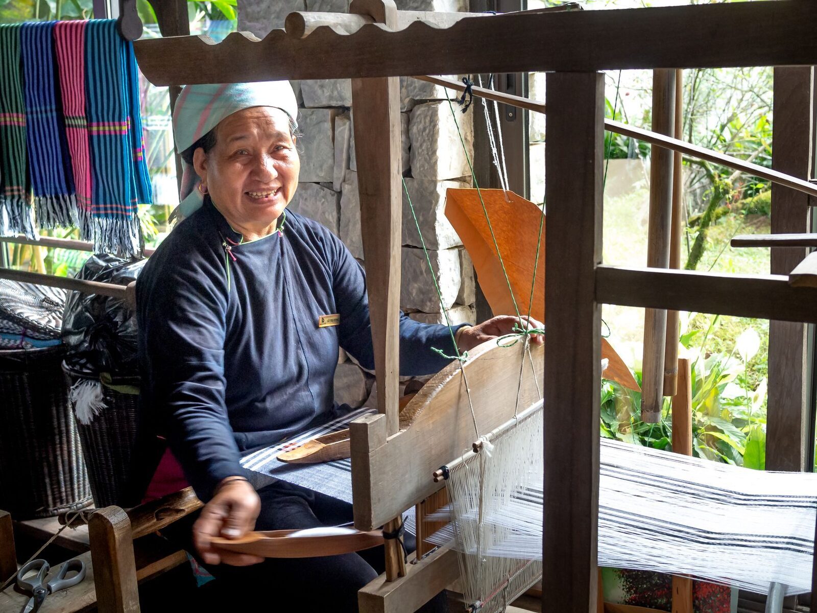 A Balinese weaver at a backstrap loom, the way the cloth has been made here for generations.