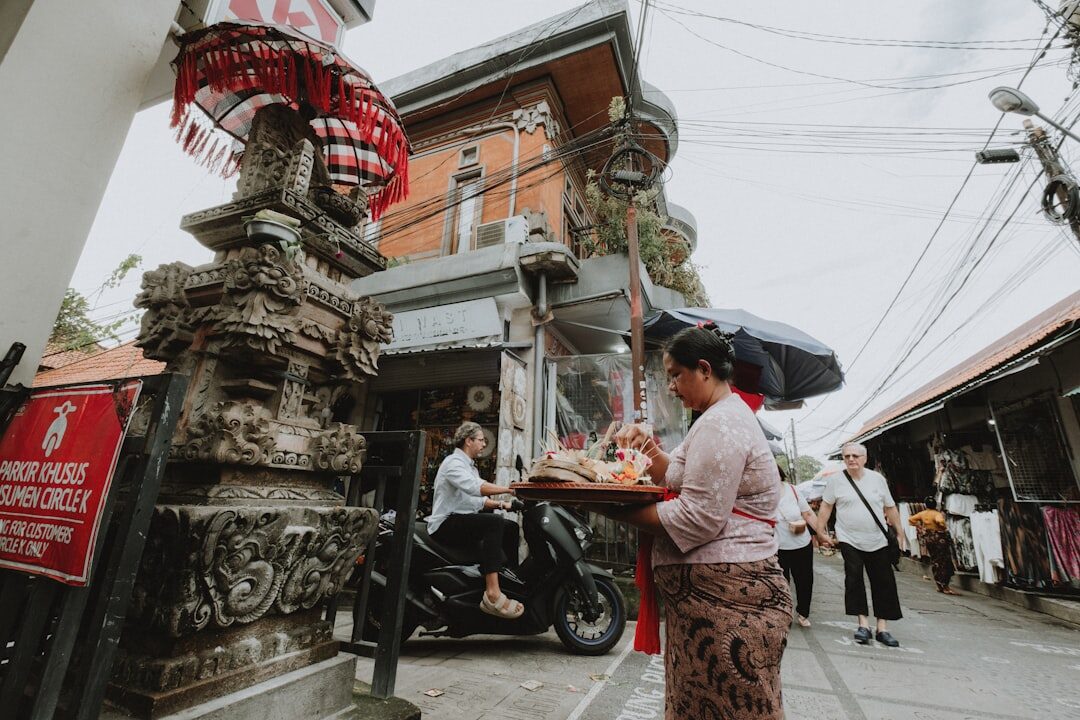 An ordinary morning at a Bali street market — stalls, sarongs, a temple gate. A woman on her own here is a normal, welcome sight, not a curiosity or a target.