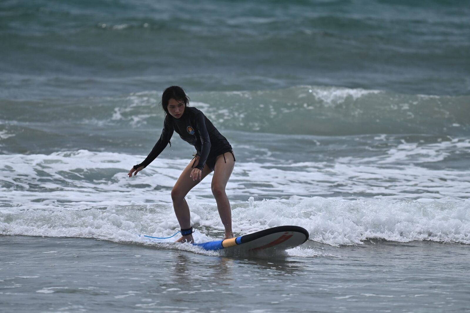 A beginner popping up on a foam board in the white-water, the gentlest way to learn.