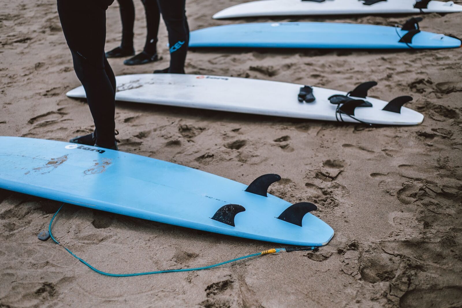 Soft-top boards lined up on the beach, the kind of rental gear included in almost every lesson.