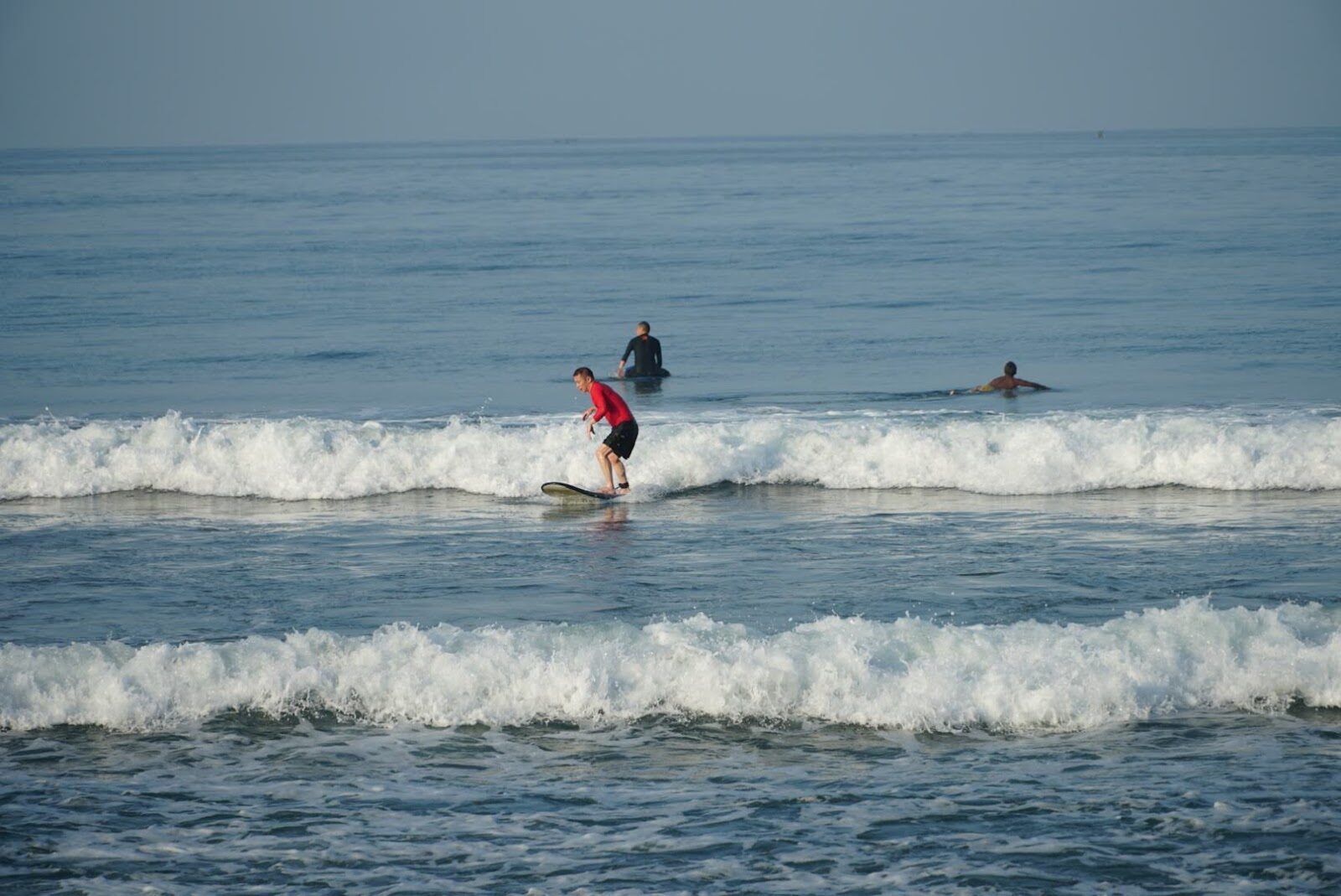 A learner riding a wall of white-water on a foam board.