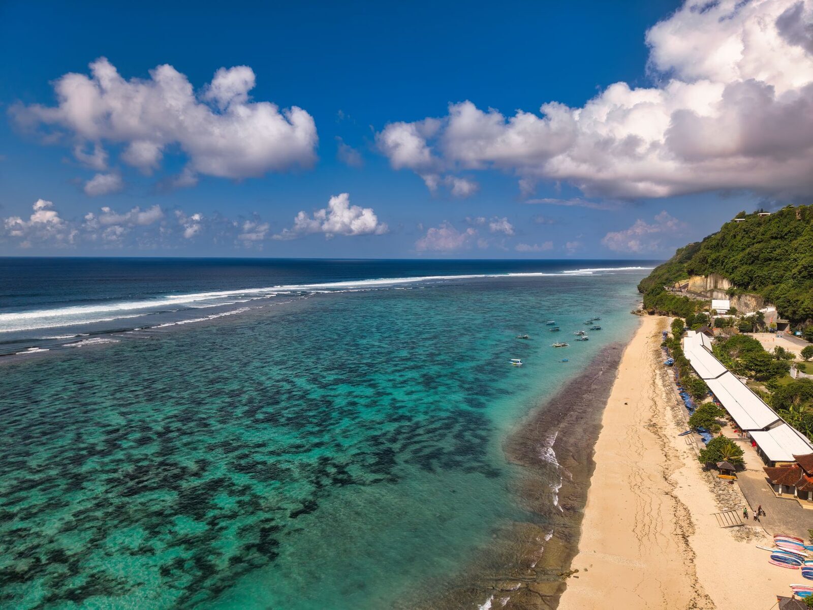 An exposed reef flat off a Bukit beach at low water — this is what sits under the surf when the tide drops.