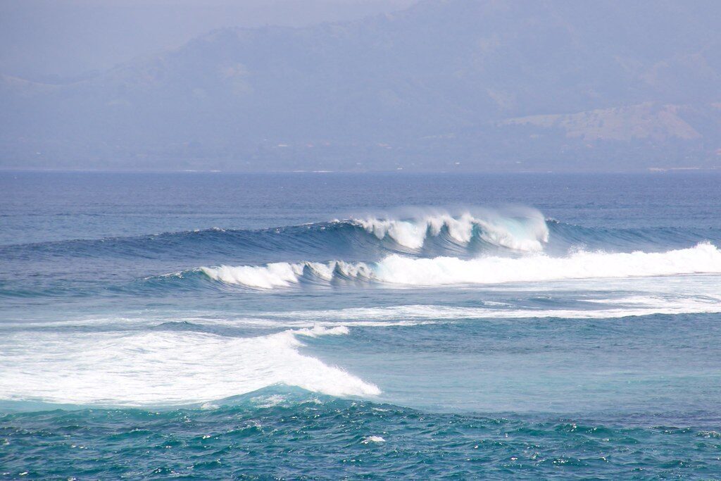 Clean lines peeling along a reef point — beautiful from the cliff, live coral underneath.
