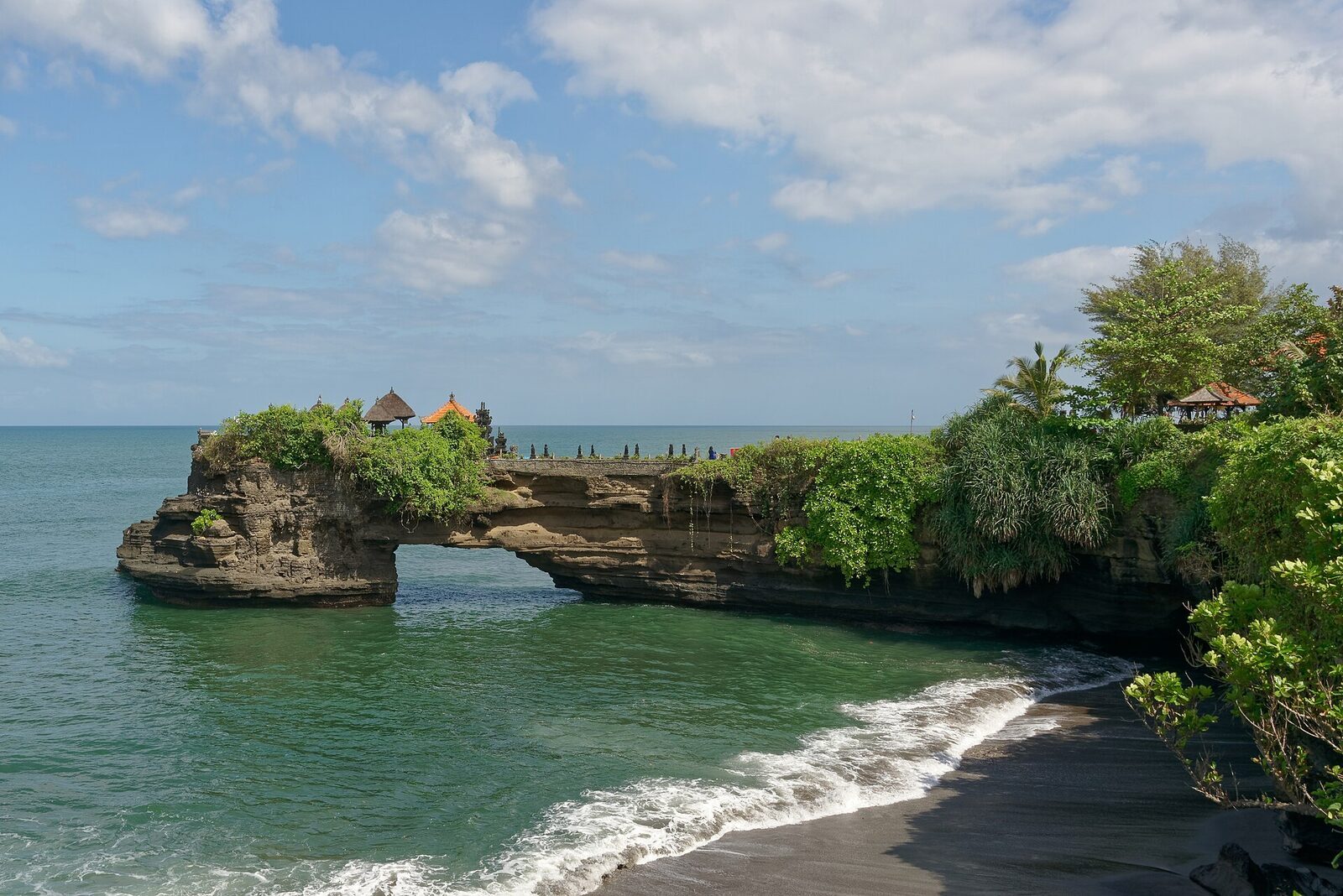 The Batu Bolong arch, a temple perched on the headland above the sea gap.