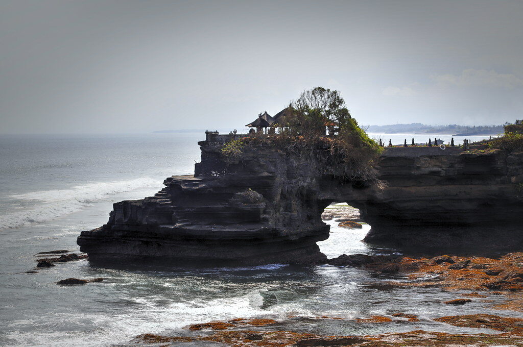Batu Bolong's temple and its wave-cut arch — the quieter neighbour to the north.
