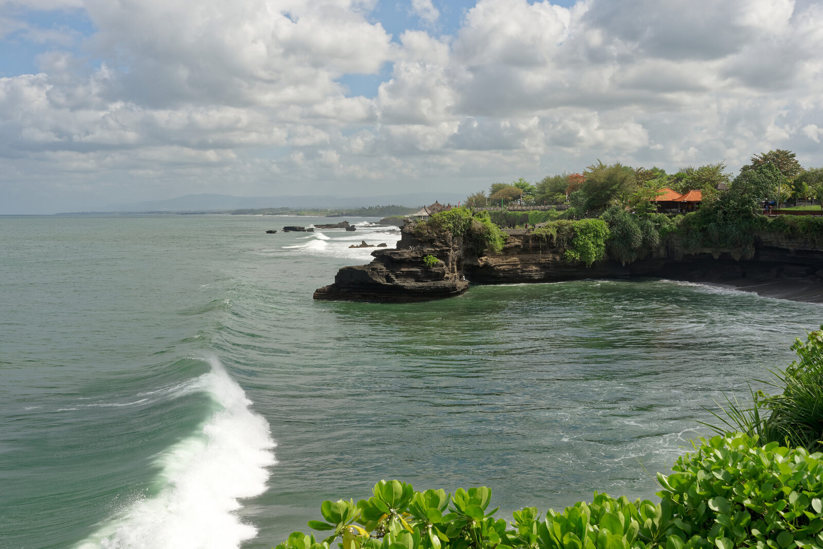 The arched headland of Batu Bolong seen along the coast.