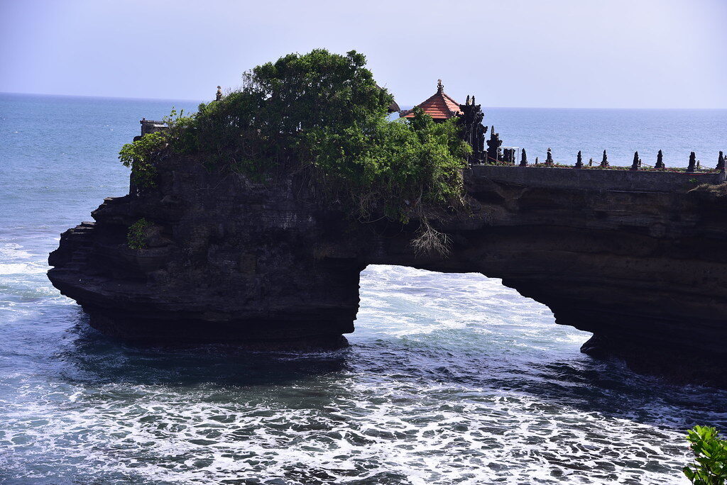 Pura Batu Bolong, the sea washing through the hole in the rock beneath the little cliff temple.