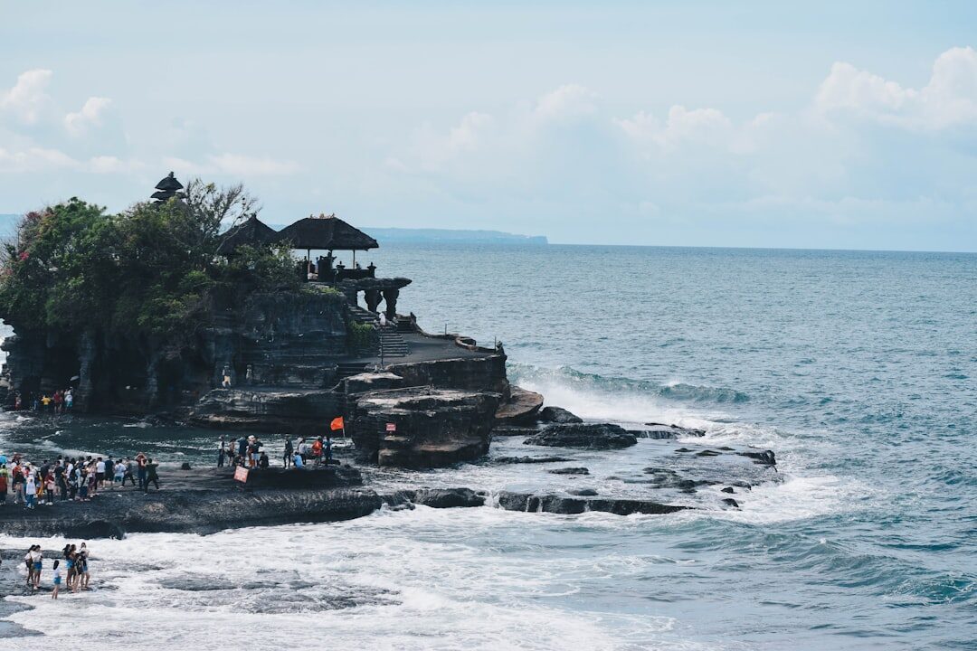 The shoreline packed with people watching the temple.