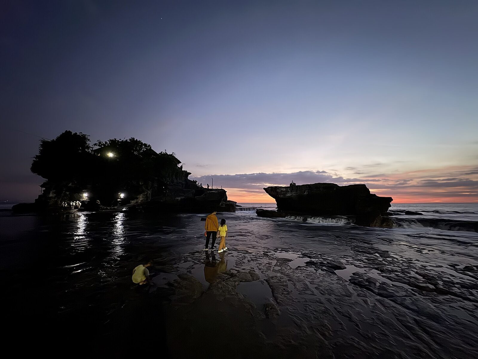 Dusk over the wet flats, the temple in silhouette above its reflection.