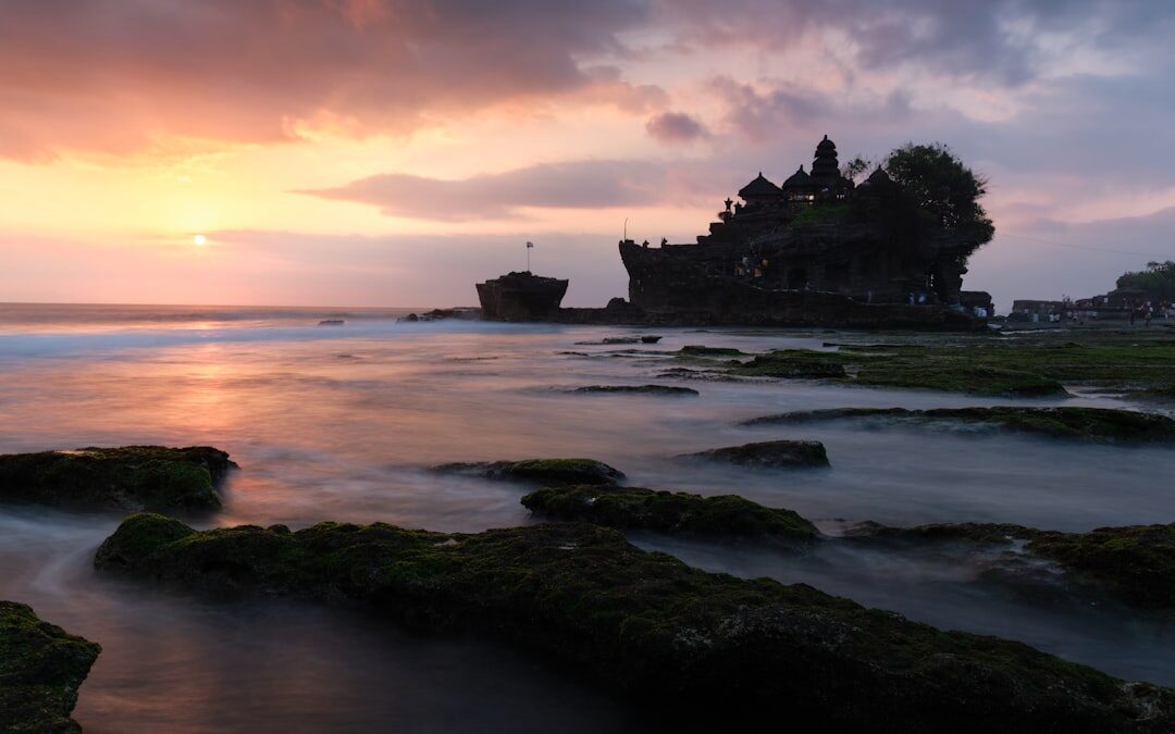 Blue dusk, long exposure, the temple silhouette above the surf.