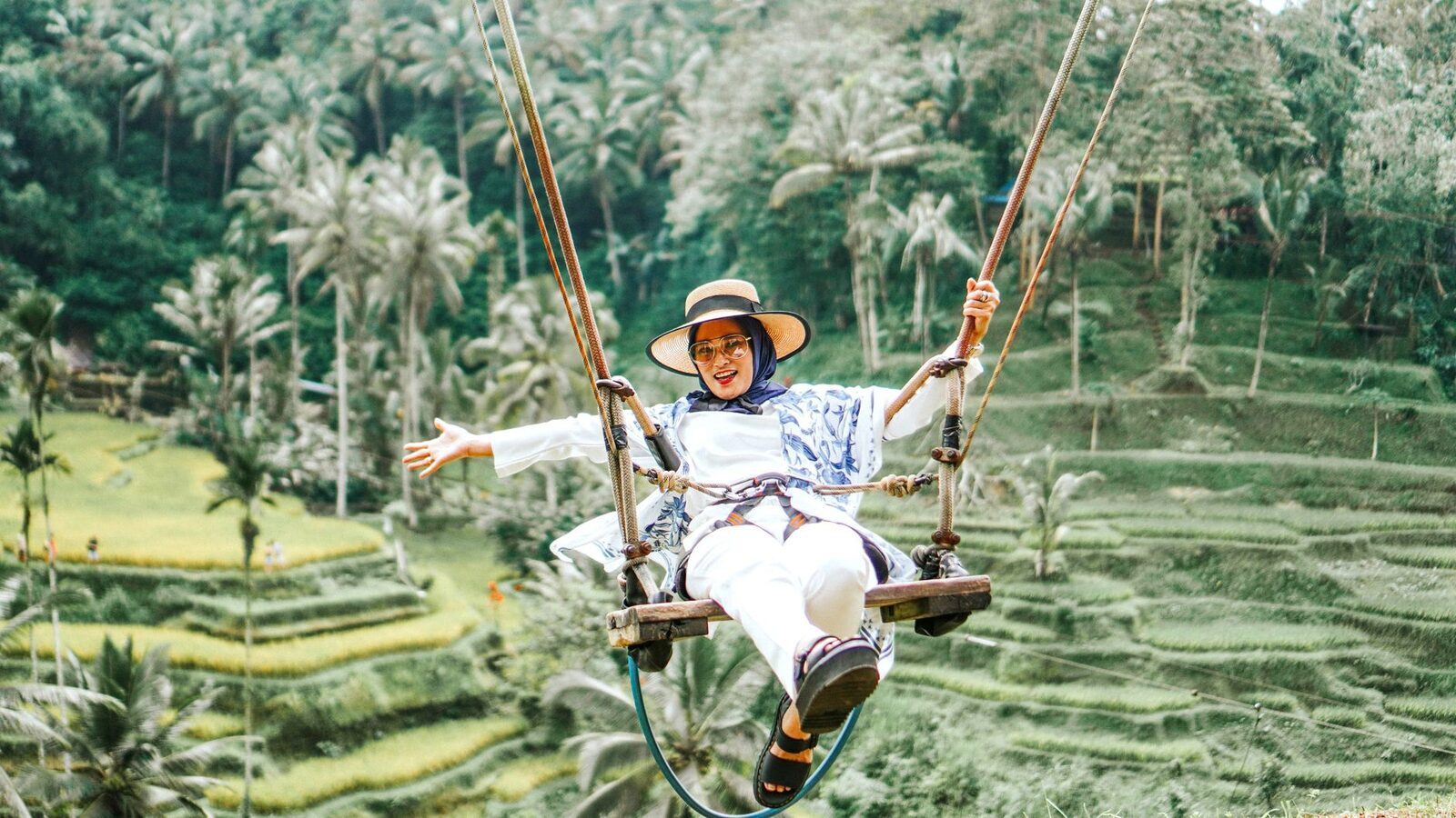A rider mid-swing out over the paddies below.
