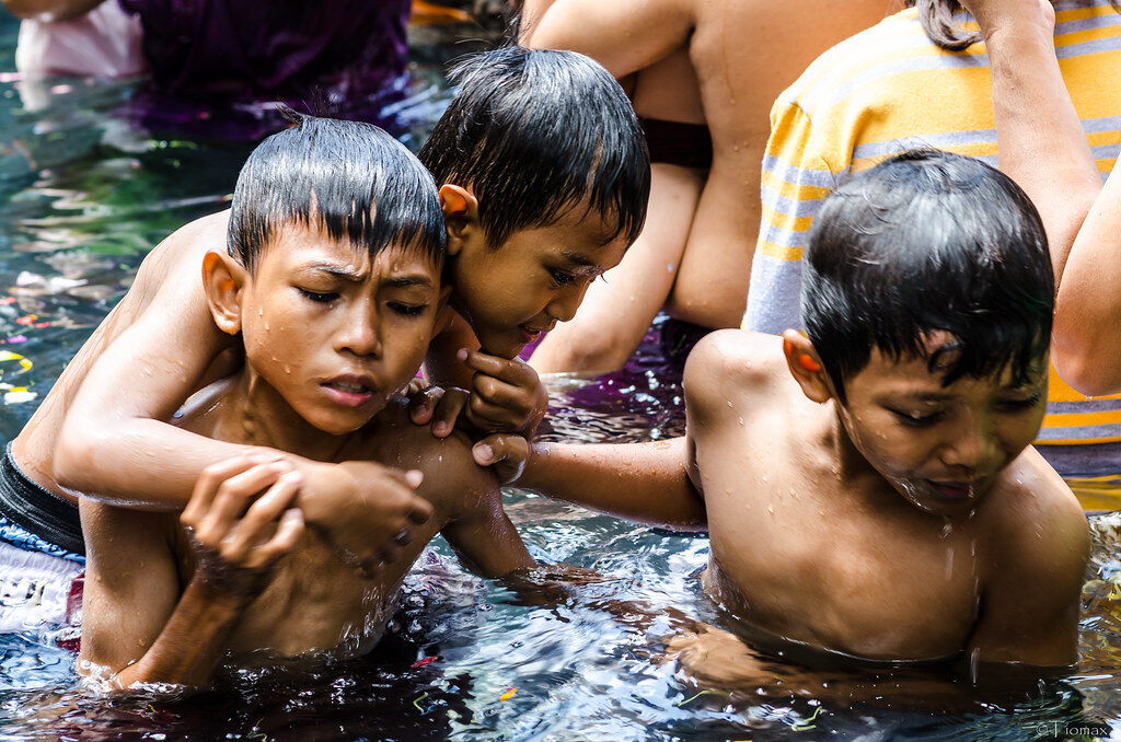 Boys in the pool during a family cleansing — this is a rite locals bring their children to.