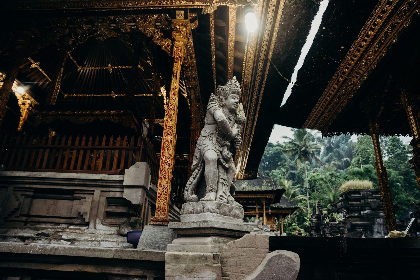 A gilded pavilion and guardian statue inside the temple.