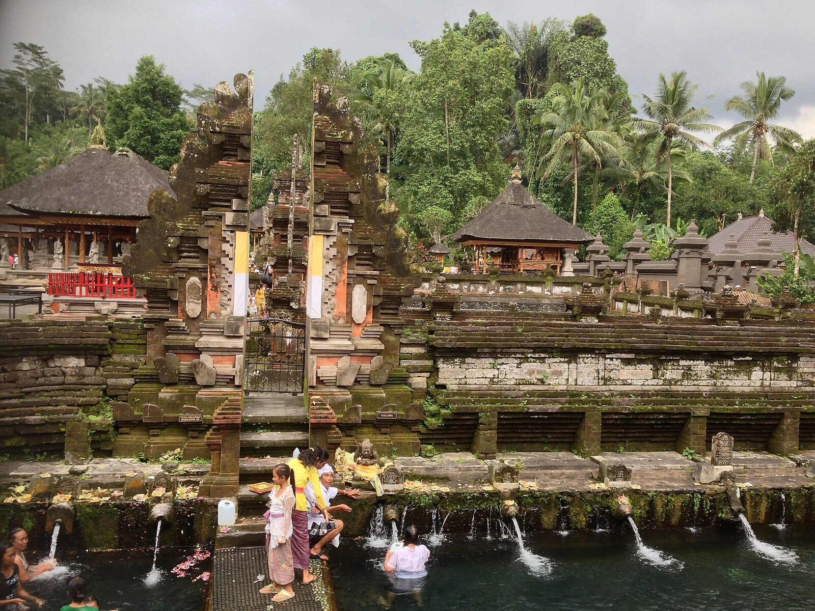 Past the pools: the inner courtyard, its split gate reflected in the temple pond most visitors never reach.