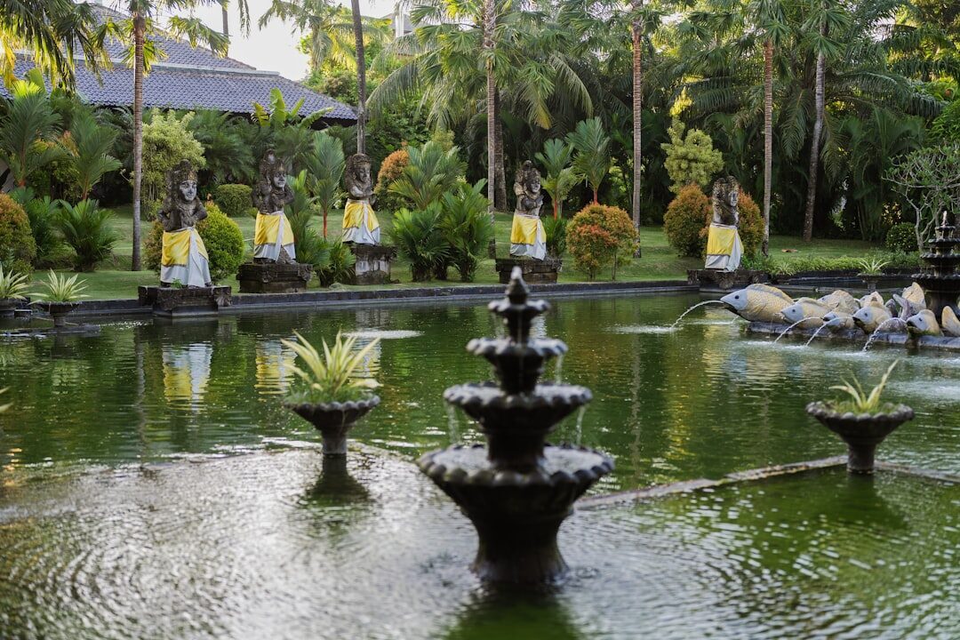 A pair of two-tier fountains flanked by stone statues.