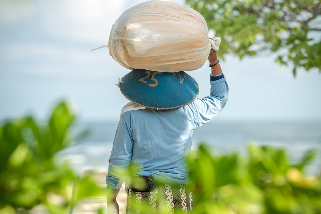 A worker carrying a load on the Bali coast