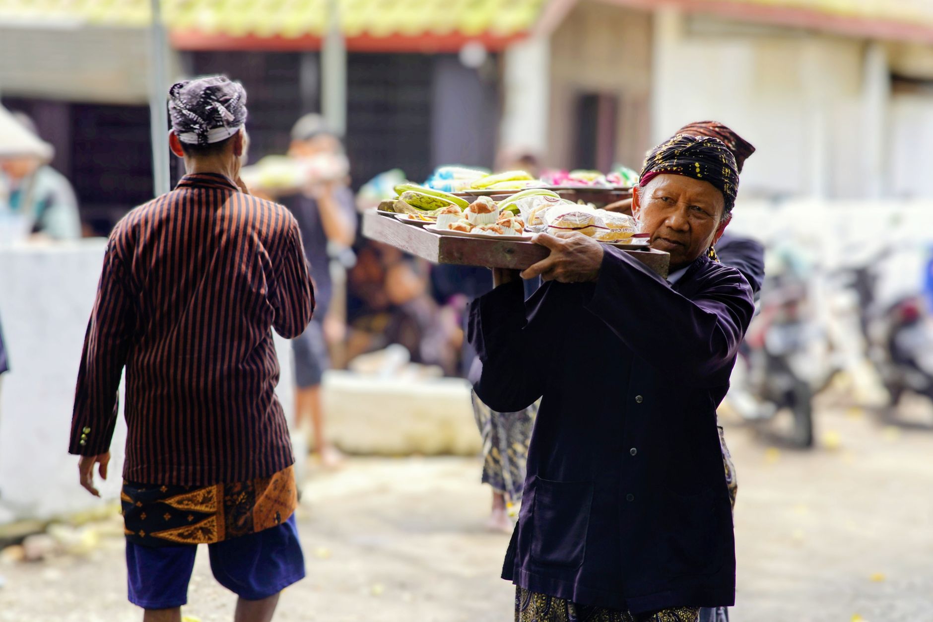 An Indonesian street vendor carrying a tray