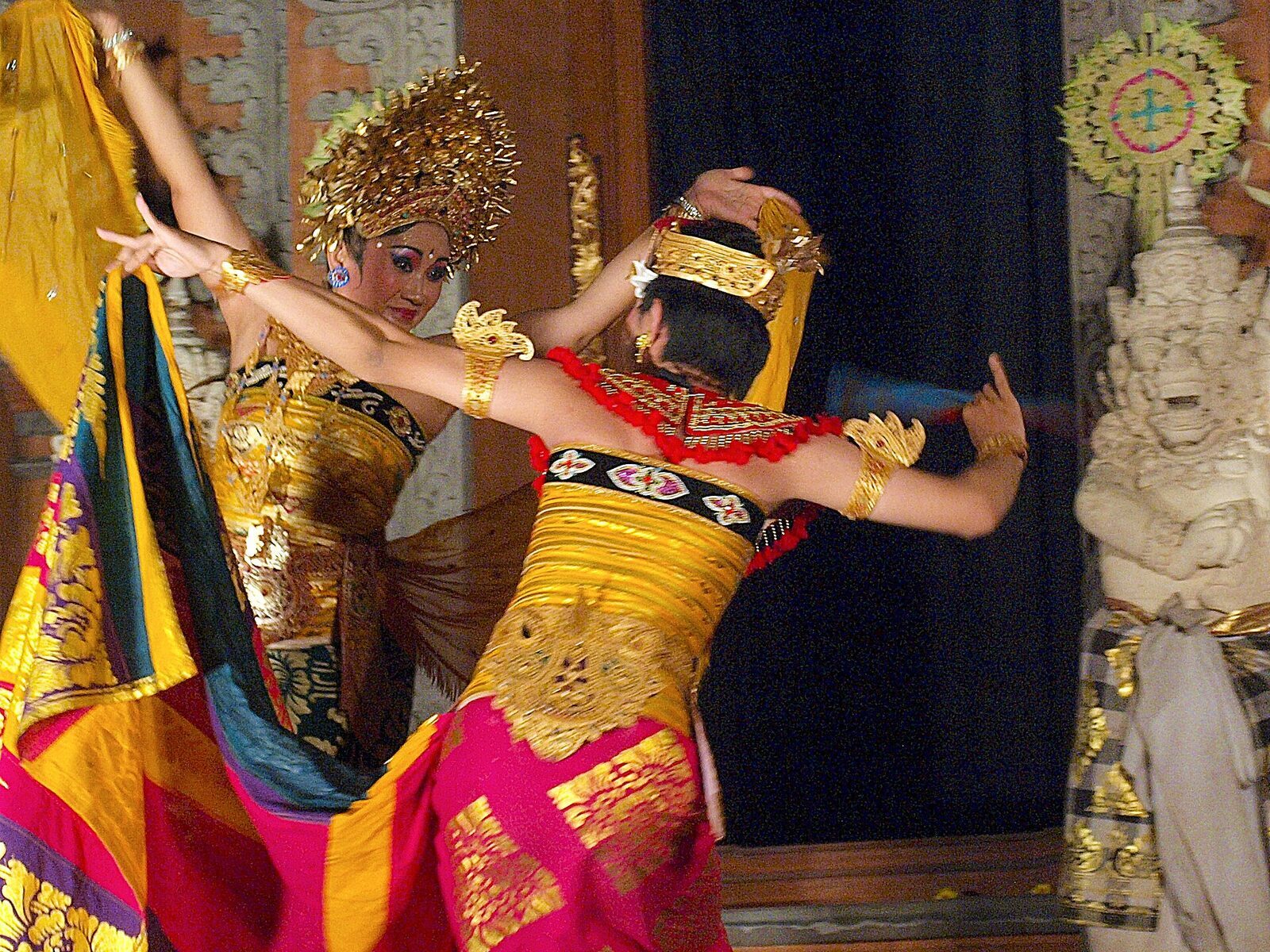 Two dancers mid-performance, arms and fingers held in the classic line.