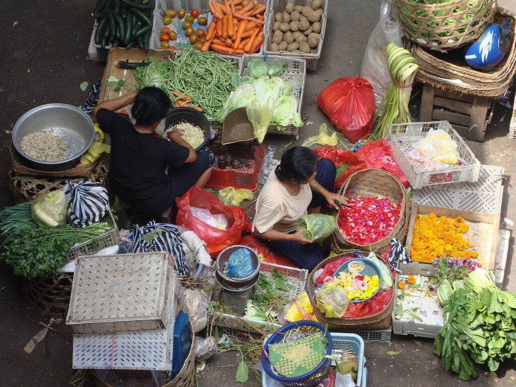 An overhead of the produce stalls — vegetables, fruit and baskets of offerings.