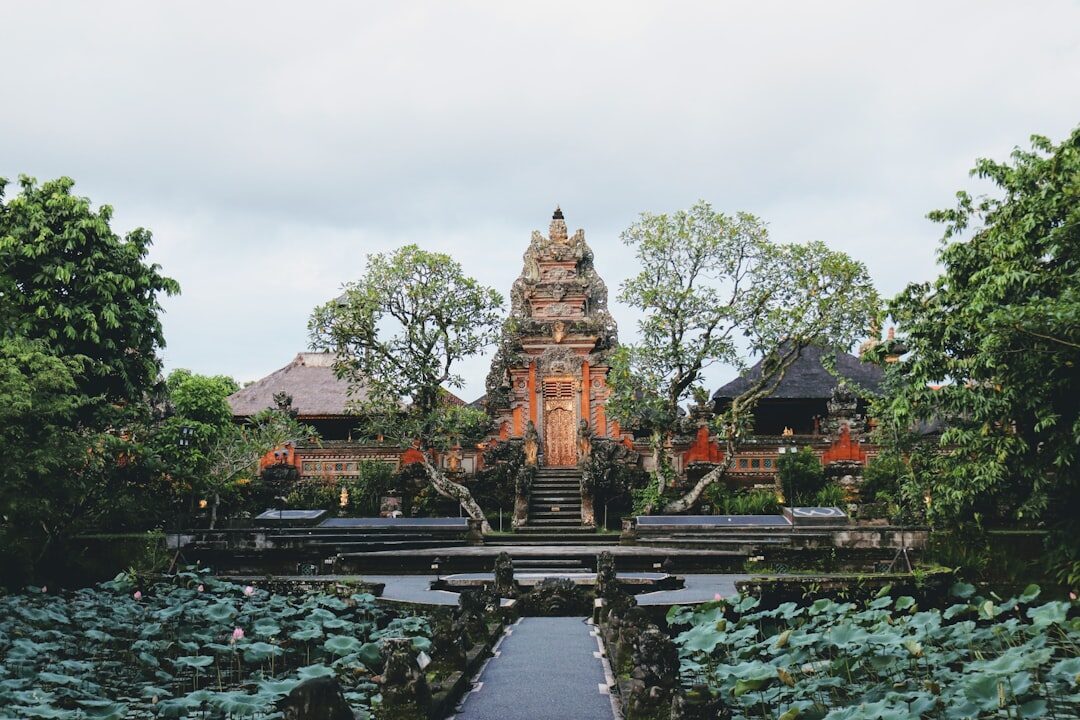 Puri Saren Agung, the Ubud royal palace, mirrored in its lotus pond — free to wander by day, a dance-stage backdrop by night.